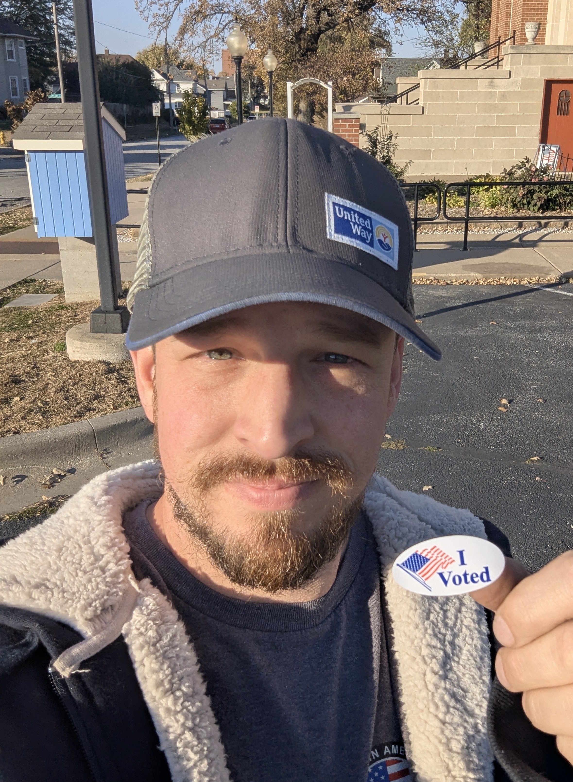 Andrew Fitzgerald holding an I Voted sticker outside a polling location