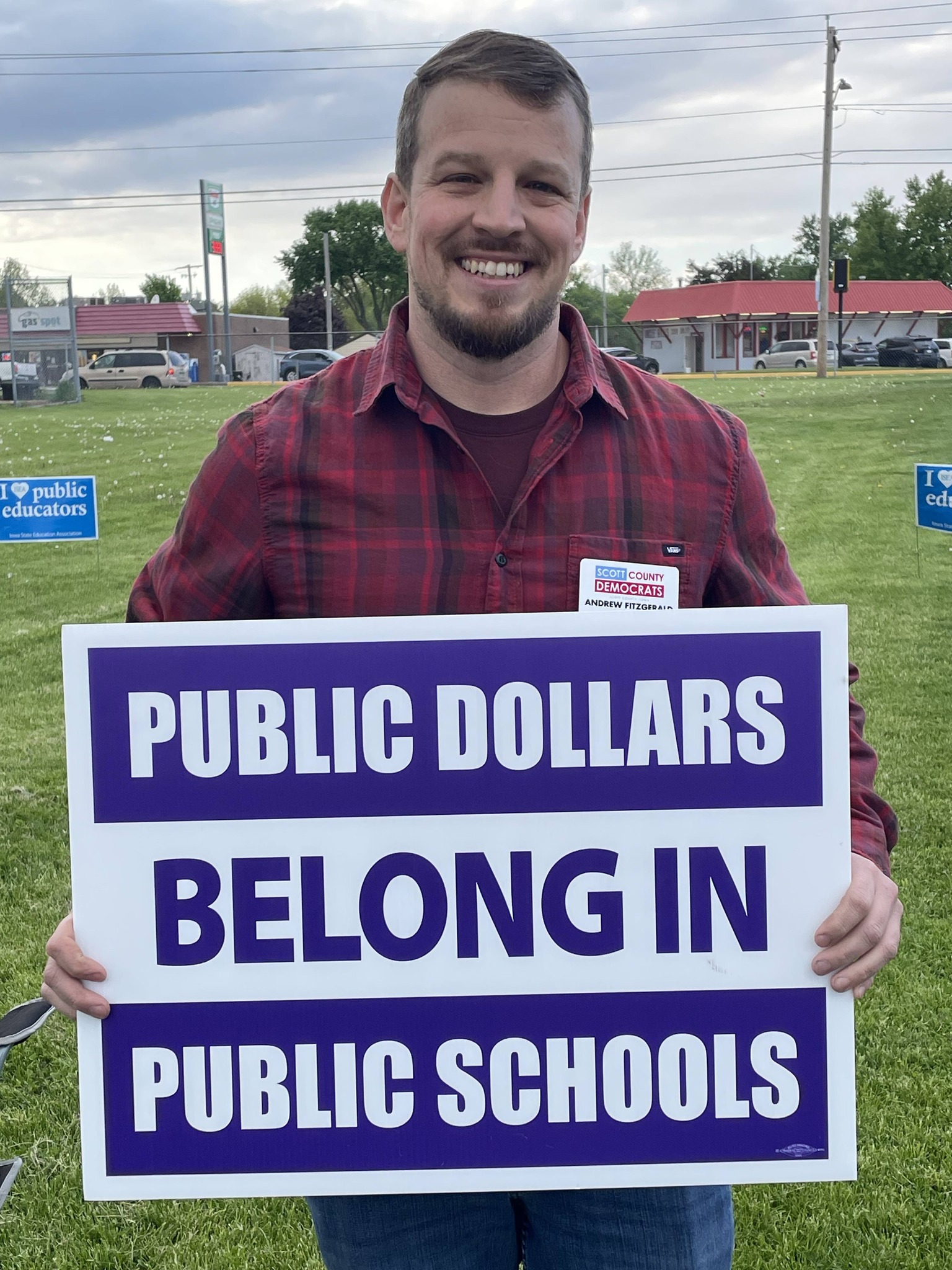 Andrew Fitzgerald holding Public Dollars Belong in Public Schools sign