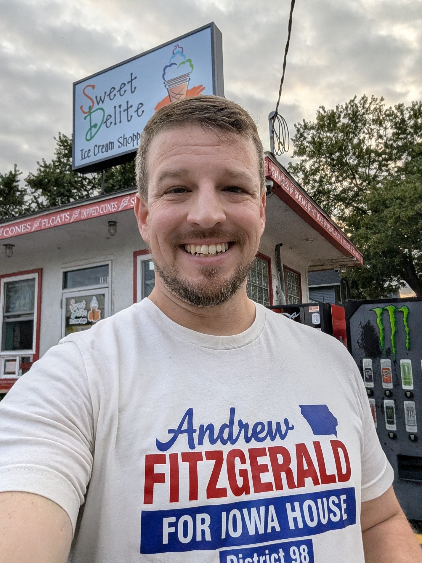 Andrew Fitzgerald in a campaign shirt outside Sweet Delite Ice Cream Shoppe